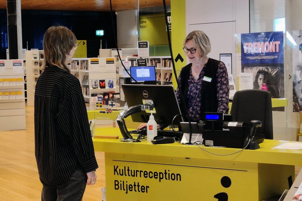 Två personer står vid en informationsdisk.