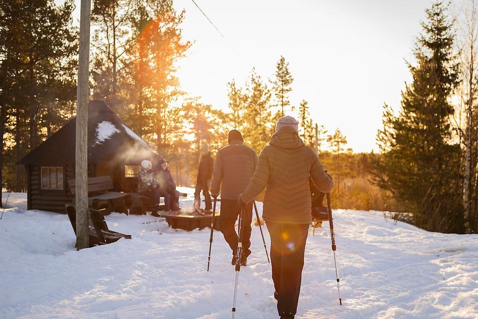 Personer på vandrar mot vindskydd i vintermiljö