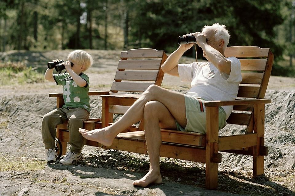 Pojke och äldre man tittar i var sin kikare