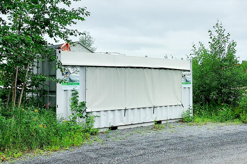 Bilden visar en grå container.